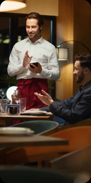 Garçom atendendo clientes felizes