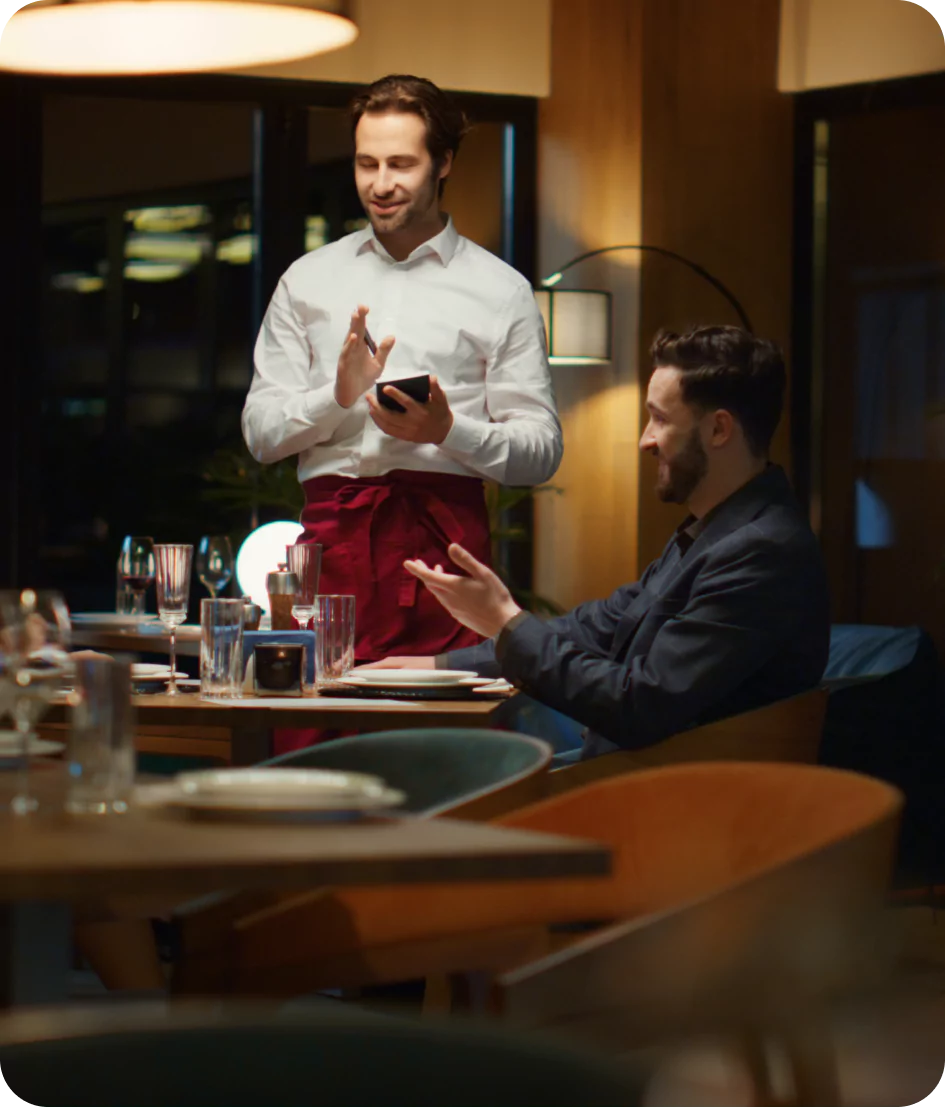 Garçom atendendo clientes felizes