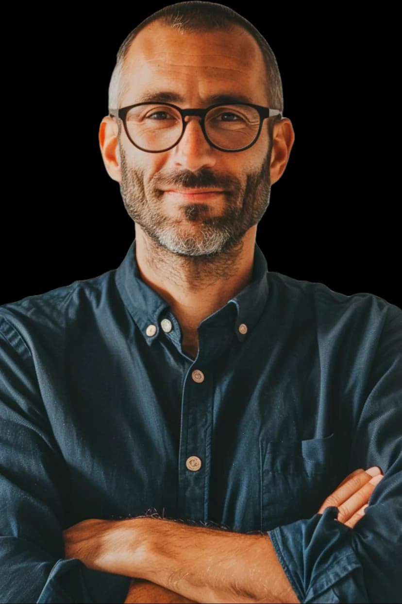 Homem sorrindo em pé de braços cruzados